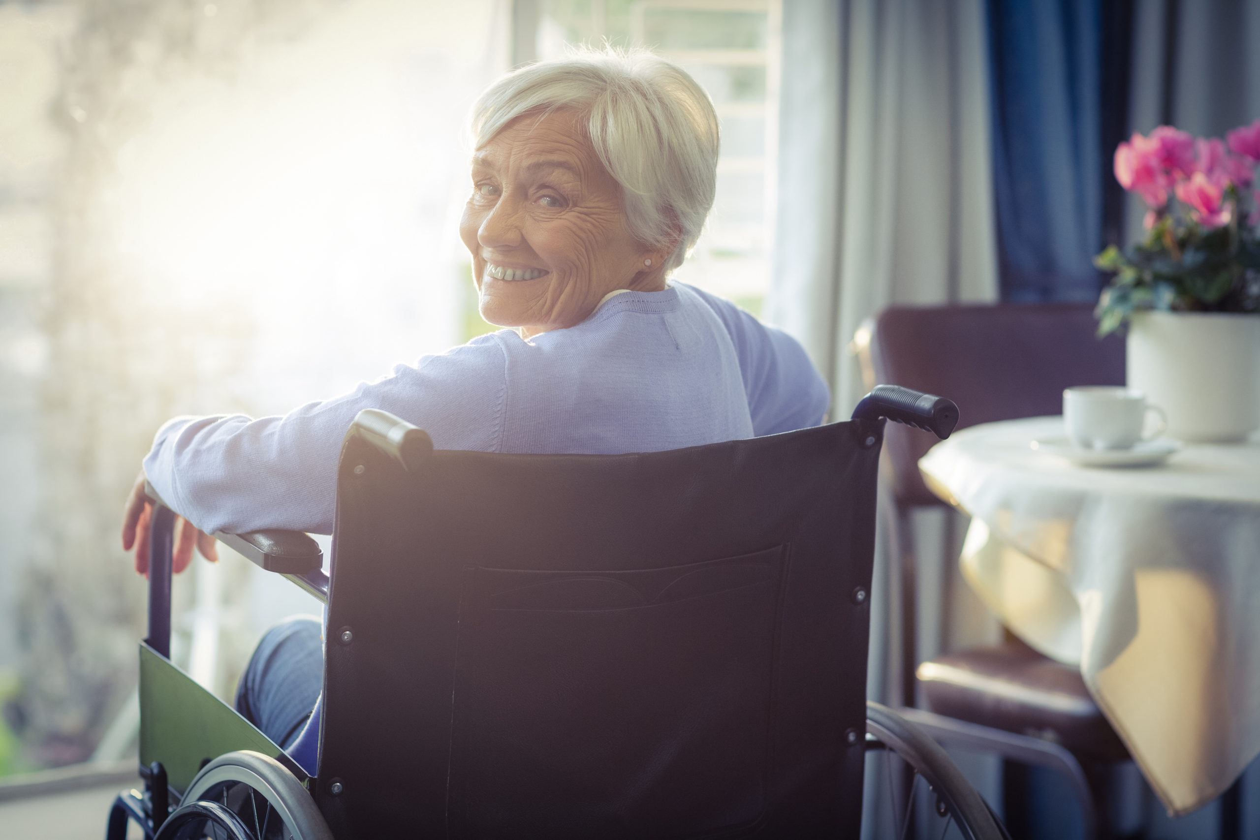 woman in a wheelchair smiling in her home