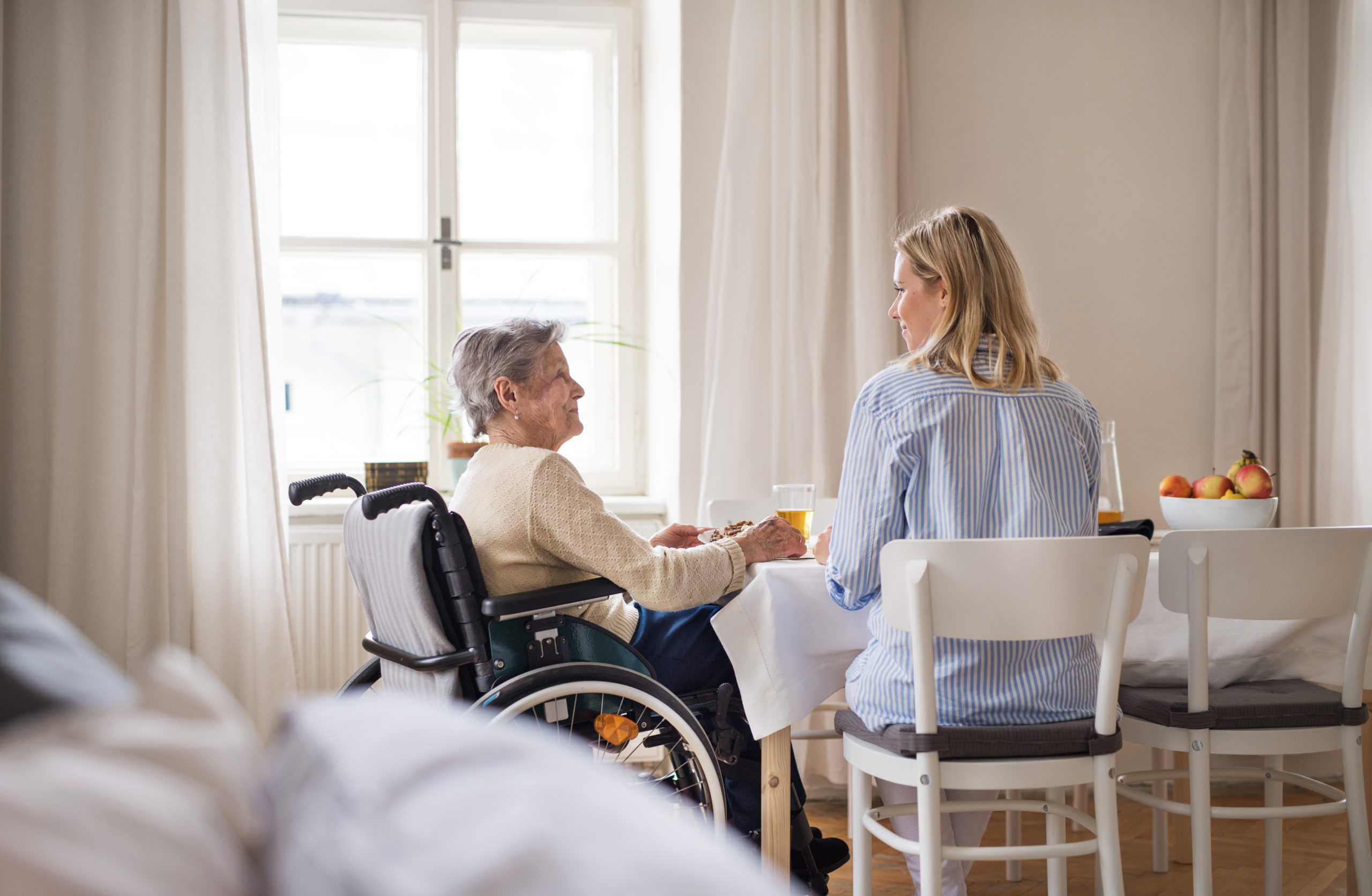 elderly woman in wheelchair at table with family